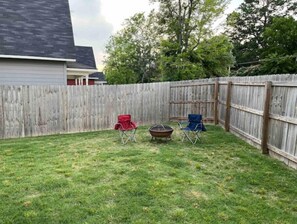 Relax in the backyard with a fire pit and comfortable lawn chairs.