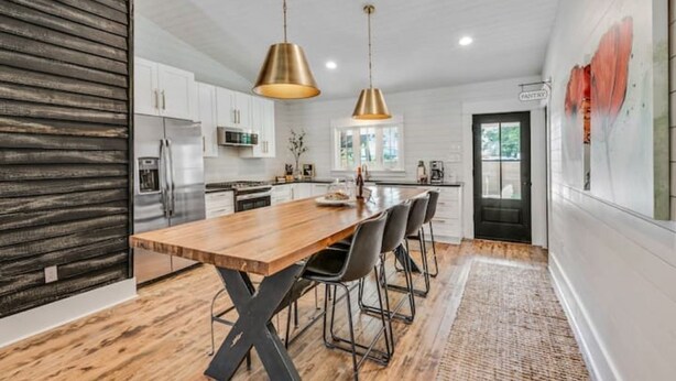 A modern kitchen with a wooden island, stainless steel appliances, and pendant lighting. - Poppy & Rye House: one block from the Silos (Waco)