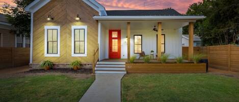 A two-story house with a red door, a covered porch, and a number 621 on the front.
