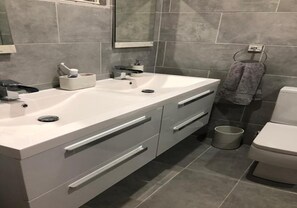 A modern bathroom with a white sink, two drawers, a mirror, and a towel rack. - Stunning 3-bed Apartment in Rodney Bay (Gros Islet)