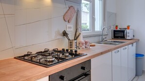 Une cuisine moderne équipée d’une cuisinière à gaz, d’un four à micro-ondes et d’un évier.