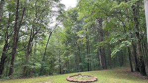 Ein bewaldetes Gebiet mit einer runden Steinanlage in der Mitte.