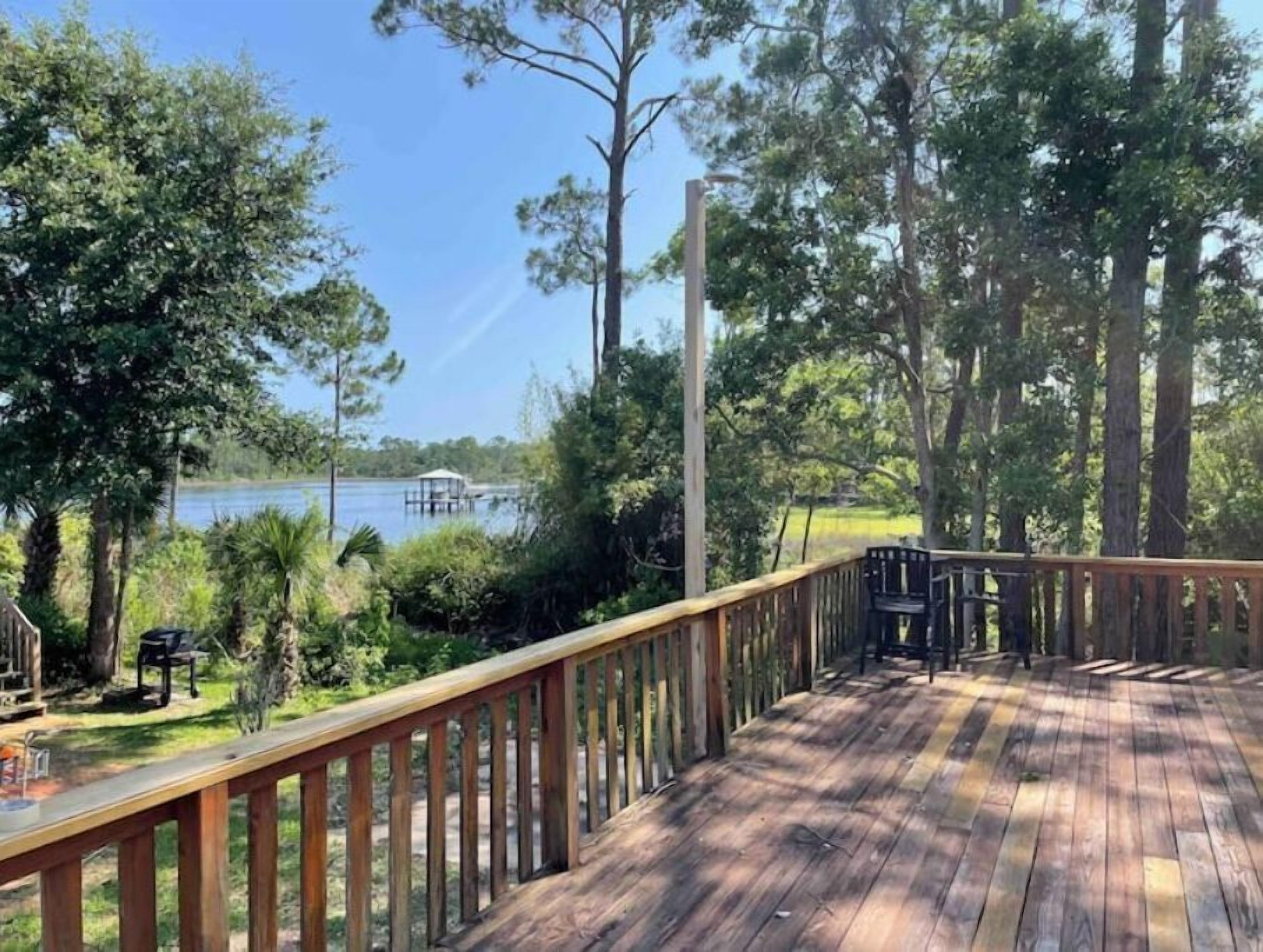 Una terraza de madera con vista a un lago y un muelle.