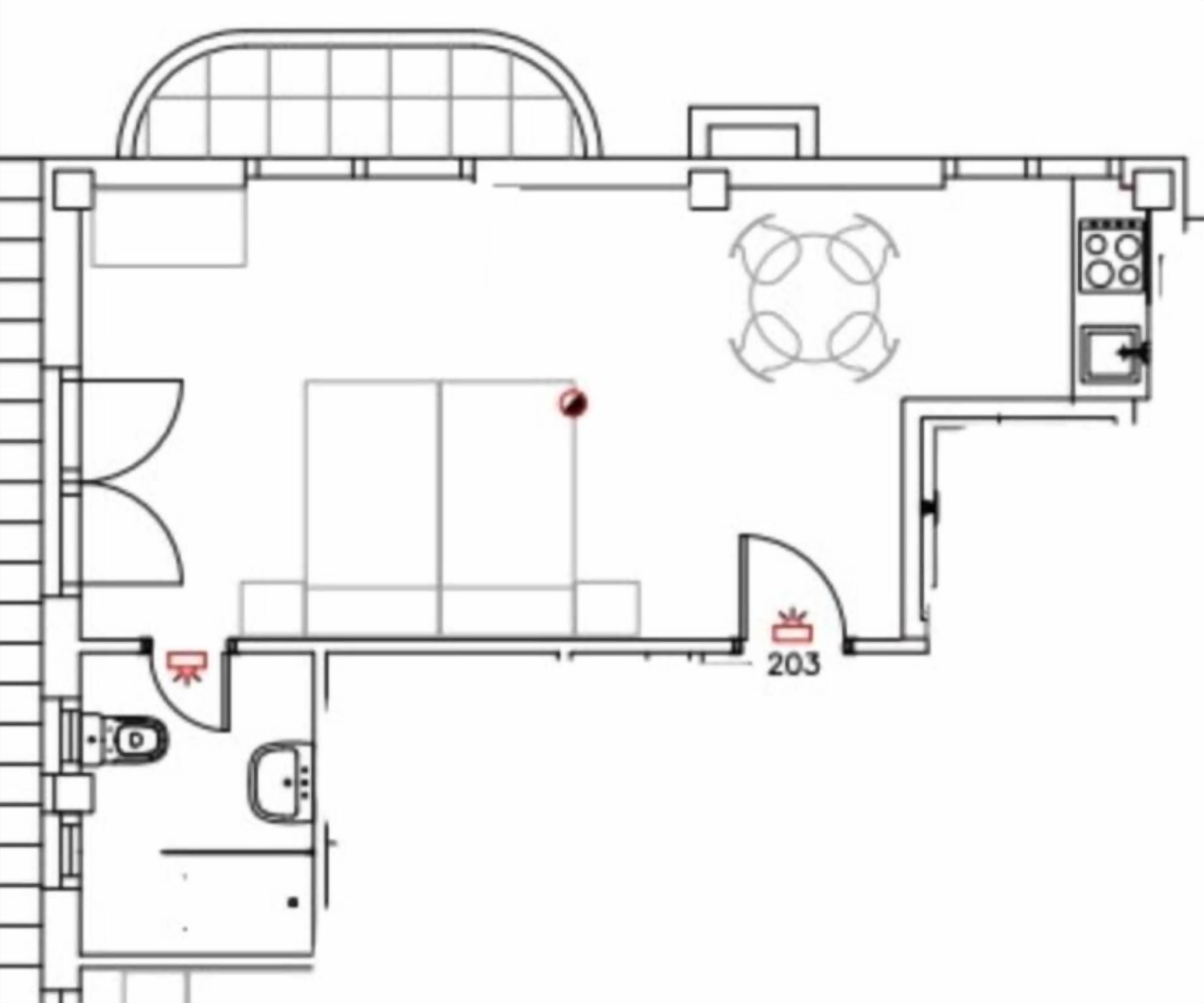 A floor plan of a hotel room with a bed, a desk, a chair, a small bathroom, and a kitchenette.
