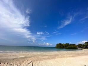 Une plage avec un ciel dégagé et une mer calme.