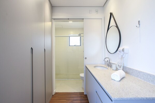 A modern bathroom with a shower, toilet, and a sink with a towel. - Arte Arquitetura Vila Mariana (São Paulo)