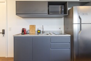 Eine moderne Küche mit integriertem Mikrowellenherd, einem Edelstahl-Kühlschrank und einer Arbeitsplatte aus Granit.