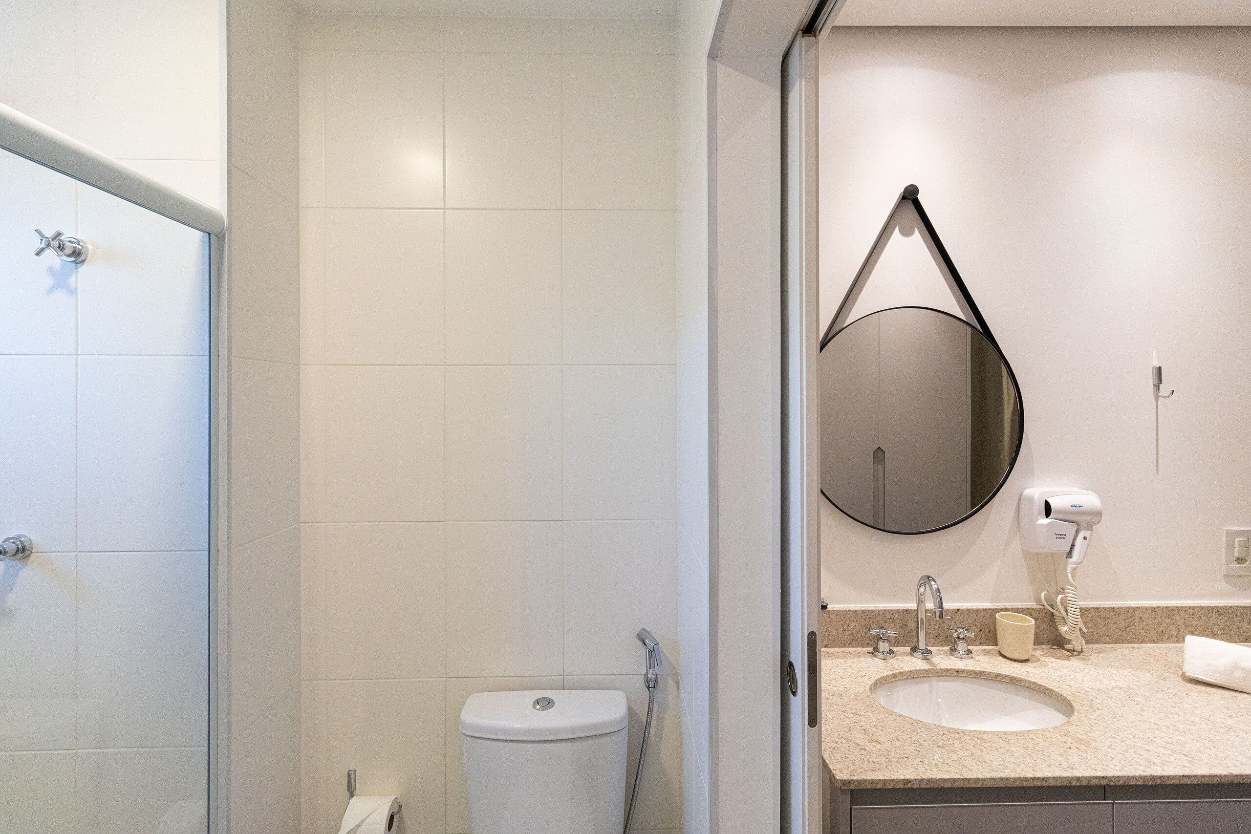 Une salle de bain avec des toilettes, un lavabo et un miroir.