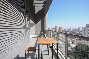 A rooftop terrace with metal railings, two wooden tables, and a view of the cityscape. - Arte Arquitetura Vila Mariana (São Paulo)