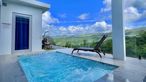 A modern outdoor swimming pool with a clear view of the surrounding landscape. - Luxury Tiny home with pool & amazing view (Caguas)