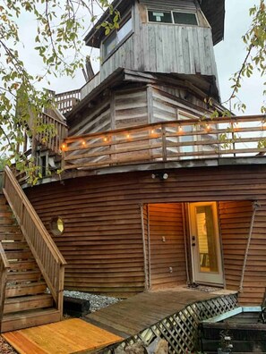 A wooden cabin with a balcony, a staircase, and a door leading to the interior. - Fantastic Ark minutes away from Nashville (Springfield)