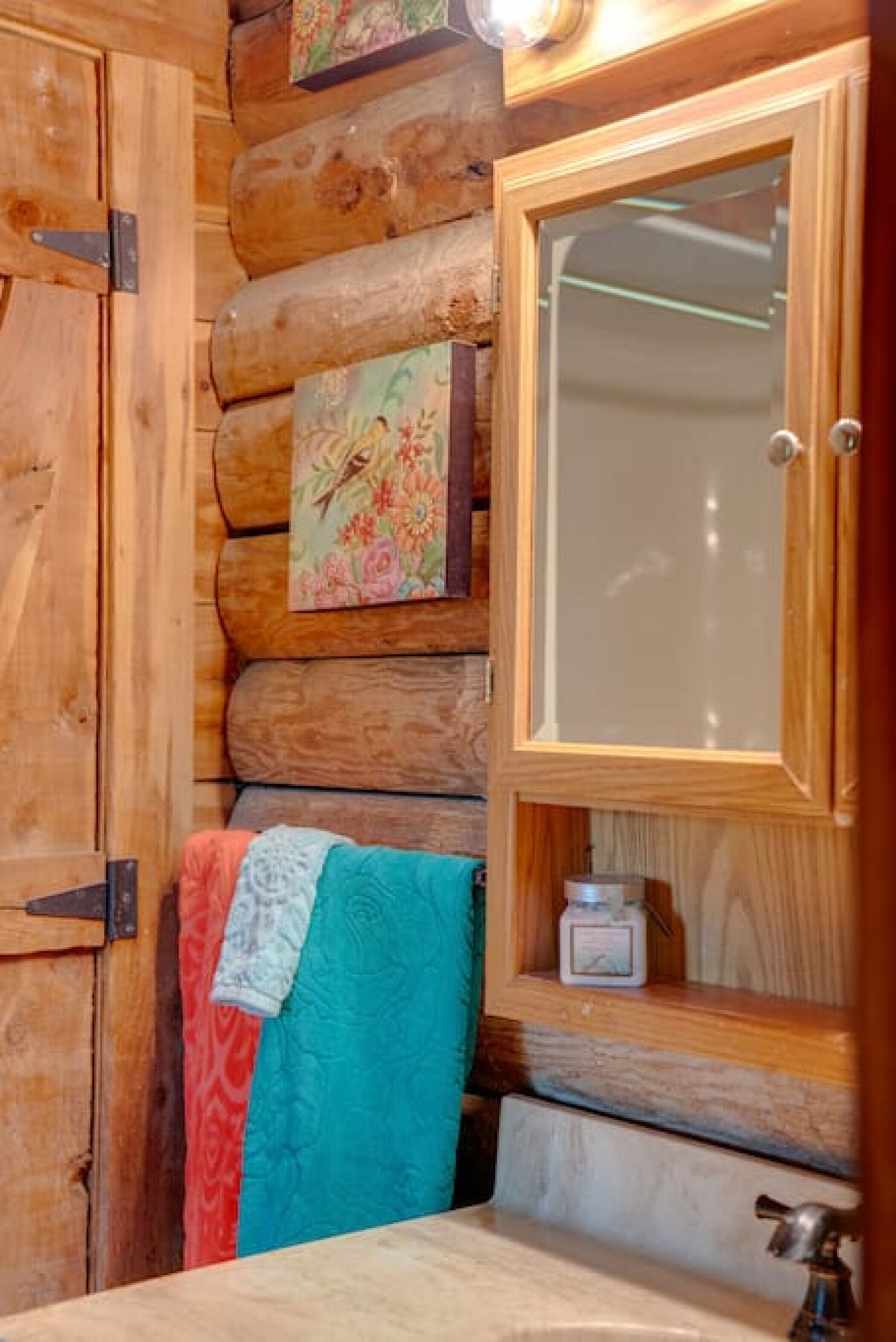 L’intérieur d’un chalet en bois, avec une porte en bois, un miroir et un porte-serviettes.