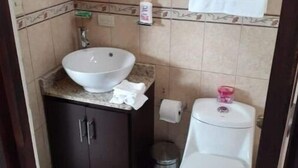 A small bathroom with a sink, toilet, and a mirror above the sink.