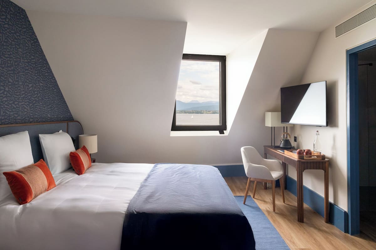 Une chambre d’hôtel moderne équipée d’un grand lit, d’un bureau, d’une chaise et d’une télévision.