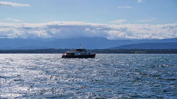 Um barco num lago calmo, com montanhas ao fundo.