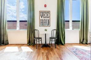 Enjoy a scenic view from the large window, with a cozy seating area featuring a round table and two chairs.