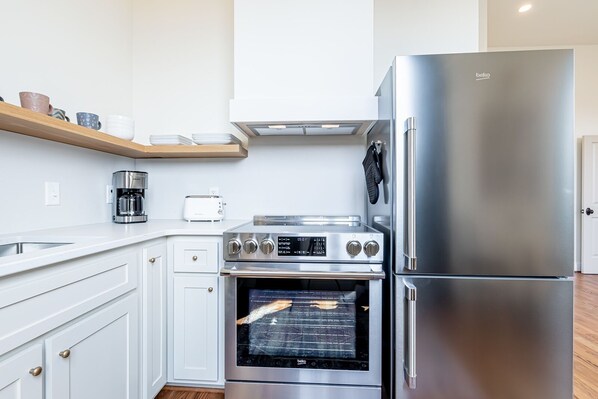 Enjoy cooking in this well-equipped kitchen with a refrigerator, oven, and coffee maker.
