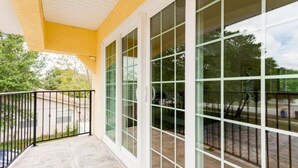 A covered balcony with a stone floor, white exterior walls, and large glass doors. - 2 houses 5bed 4bath heated pool prime location (Valrico)