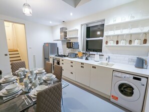 Enjoy cooking in this well-equipped kitchen with a central island, sink, and stainless steel range hood.