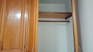 Un armario de madera con puerta espejada y una repisa.