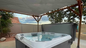 Ein Whirlpool in einer Außenanlage, überdacht mit einer Pergola.