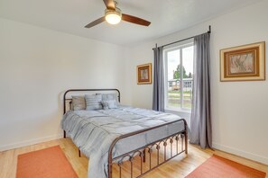 A bedroom with a bed, a ceiling fan, a window with curtains, and two framed pictures on the wall. - Rural Mountain-View Home Near Hiking + Off-Roading (Tabiona)