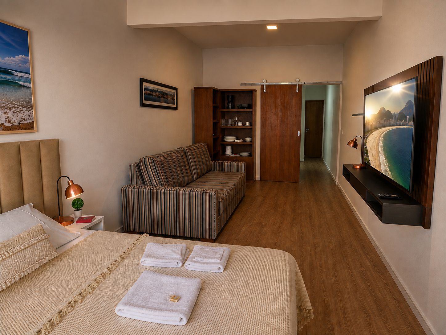 Ein Hotelzimmer mit einem Bett, einem Sofa, einem Fernseher und einem Bücherregal.