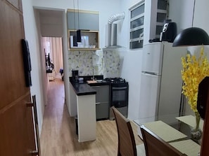 Una cocina compacta con una isla central, estufa y refrigerador.