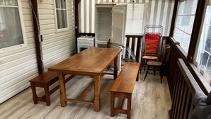 A wooden dining table with benches in a room with wooden flooring, a window, and a radiator. - Mobil Home Gère Belesten (Gère-Bélesten)
