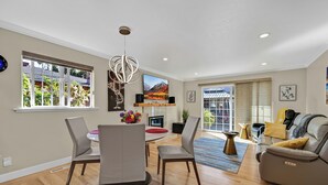Un salon moderne comprenant un coin repas, un canapé et une cheminée.