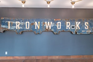 A wall with the text "IRONWORKS EST 2020" in a distressed metal style. - Elegant Retreat in the Heart Old Town Victoria (Victoria)