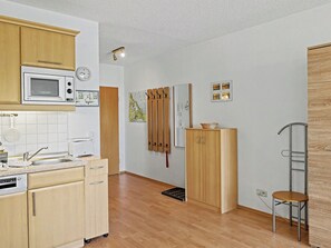 A compact kitchen with a microwave, sink, and cabinets. - Düneneck App.17 by Interhome (Zempin)