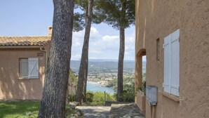 Un camino de piedra que conduce a un edificio con vistas al paisaje costero.