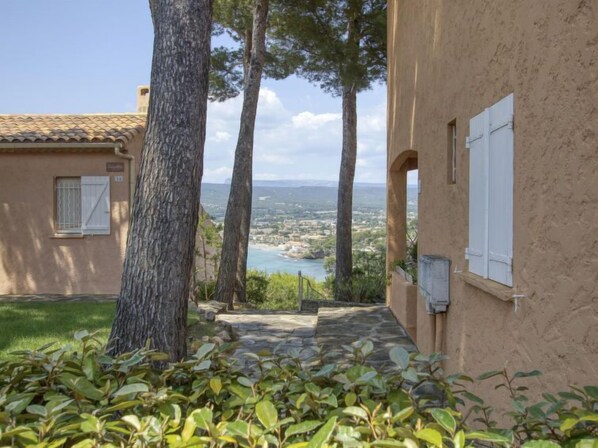 Un camino de piedra que conduce a un edificio con vistas al paisaje costero.