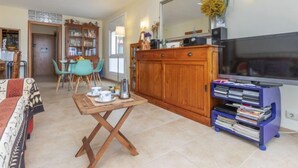 Una sala de estar con un mueble de madera, un televisor y una estantería.