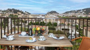 Una mesa de madera preparada para el desayuno, con vistas a un paisaje urbano.
