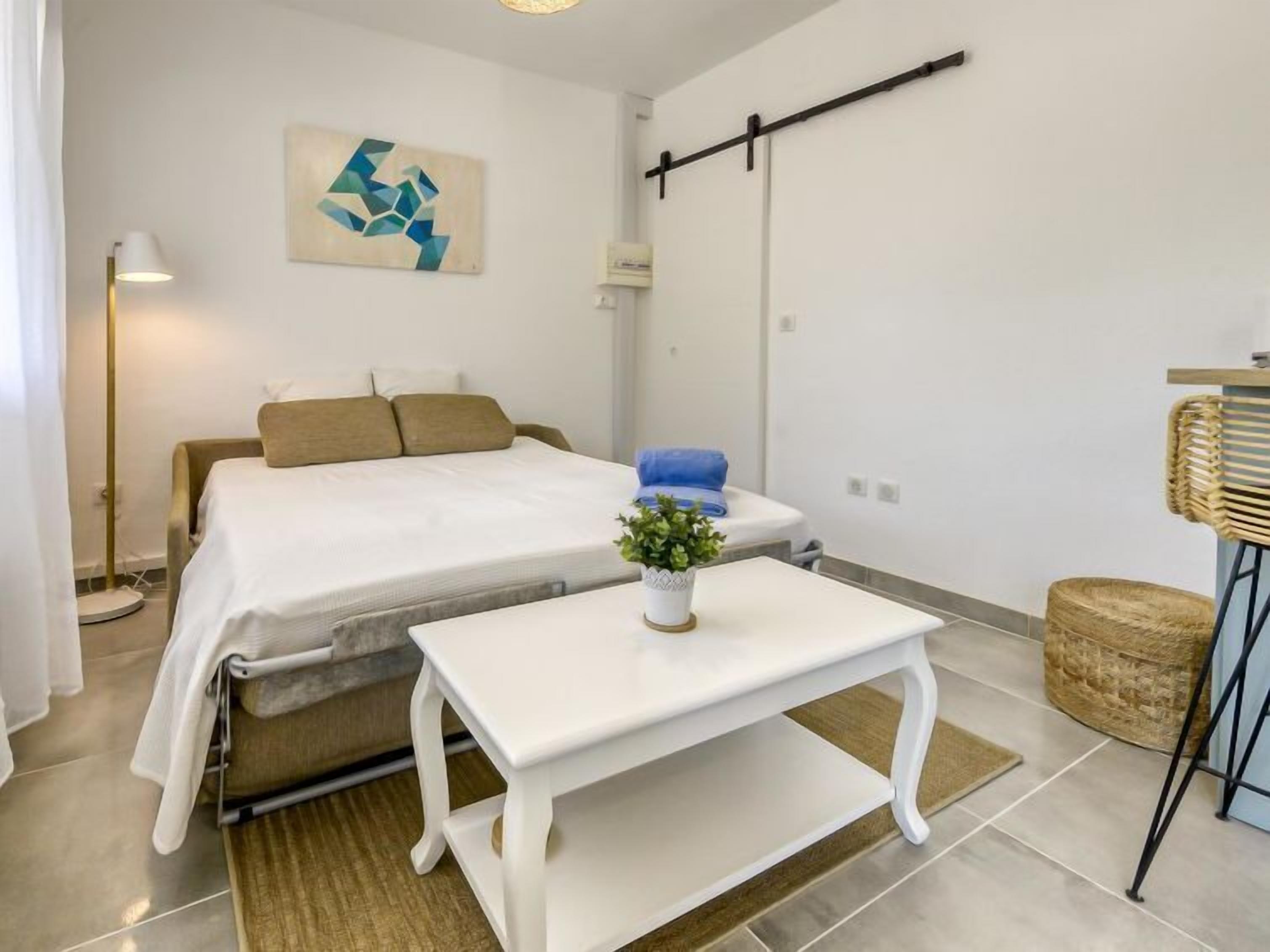 Une chambre à coucher moderne avec un lit, une table de chevet et une petite plante en pot.