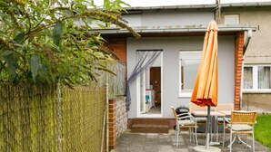 A patio area with a table and chairs, a covered seating area, and a view of the house. - Ruprecht by Interhome (Zinnowitz)