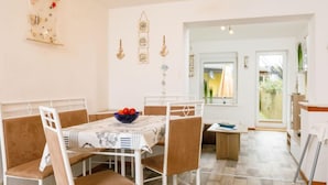 A dining area with a table set for four, chairs, and a decorative wall hanging. - Ruprecht by Interhome (Zinnowitz)