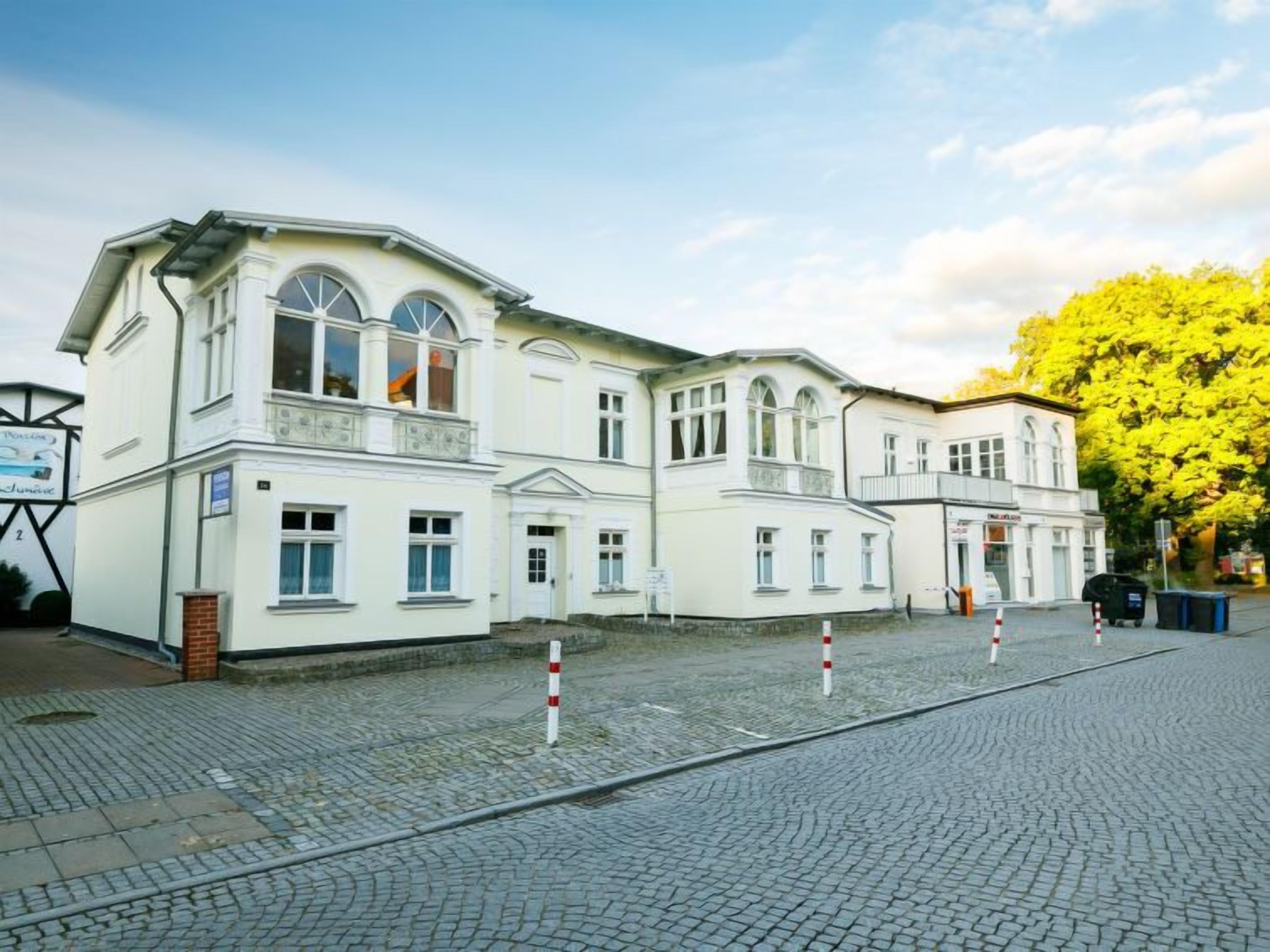 A historic building with a symmetrical facade, large windows, and a central entrance.