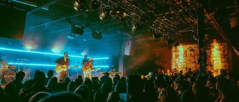 A concert with a band performing on stage, surrounded by an audience.