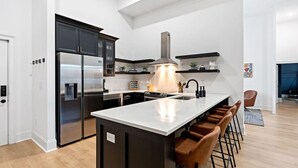 A modern kitchen with a central island, stainless steel appliances, and a large window. - Luxury 6 Bed 3 Bedroom Walk to Restaurants +Coffee (Nashville)