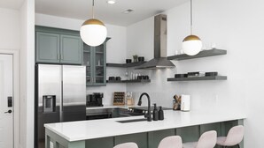 A modern kitchen with a central island, bar stools, and pendant lighting. - Condo with Free Parking, 3 miles Downtown, near Restaurants (Nashville)