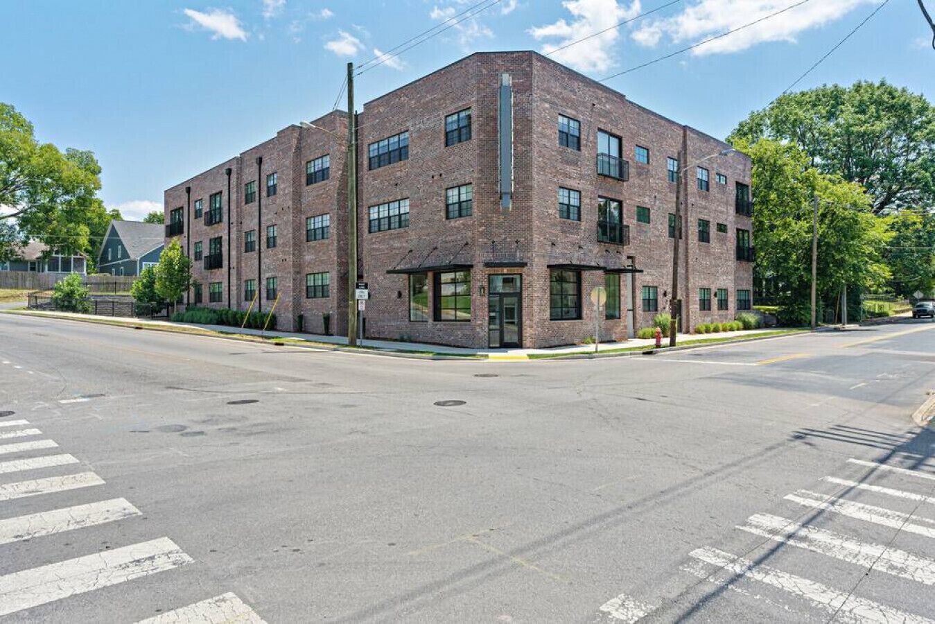 A multi-story brick building with large windows and a flat roof.