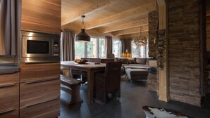 A modern kitchen with a built-in oven and a dining area with a wooden table and chairs.