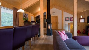 A wooden interior with a dining area, sofa, and a fireplace. - #23 mir IR-Sauna und Sprudelbad Innen by Interhome (Turracher Höhe)
