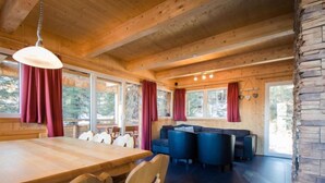A wooden interior with a dining table, chairs, and a sofa. - # 25 mit Sauna und Sprudelbad innen by Interhome (Turracher Höhe)