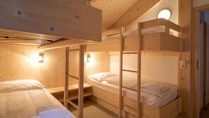 A wooden bunk bed room with a sloped ceiling and a circular light fixture. - # 25 mit Sauna und Sprudelbad innen by Interhome (Turracher Höhe)