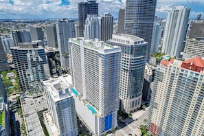 A high-rise urban area with modern architecture, including a building with a rooftop pool. - The Club- RE Rentals (Miami)