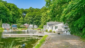 Una propiedad frente al lago con un muelle, un bote pequeño y varias casas con terrazas.